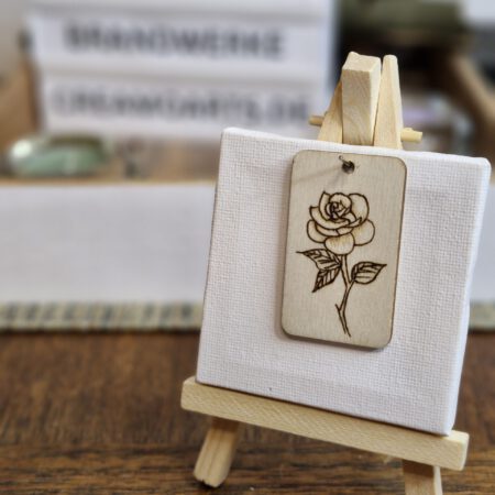 Dieser rechteckige Schlüsselanhänger zeigt eine ausdrucksstarke Rose im traditionellen Tattoo-Stil. Klare Linien, starke Kontraste und eine zeitlose Symbolik machen dieses Motiv zu einem besonderen Hingucker. Die Rose steht für Liebe, Stärke und Leidenschaft – und zieht mit ihrem markanten Look sofort die Blicke auf sich. Das Motiv wurde von Hand mit Pyrografie ins Holz gebrannt. Jedes Exemplar ist ein handgefertigtes Unikat aus unserem Atelier – charaktervoll, langlebig und mit besonderer Haptik. Ob als Geschenk oder für dich selbst: Dieses Brandwerk passt zu allen, die florale Kunst und den Stil klassischer Tattoos lieben.